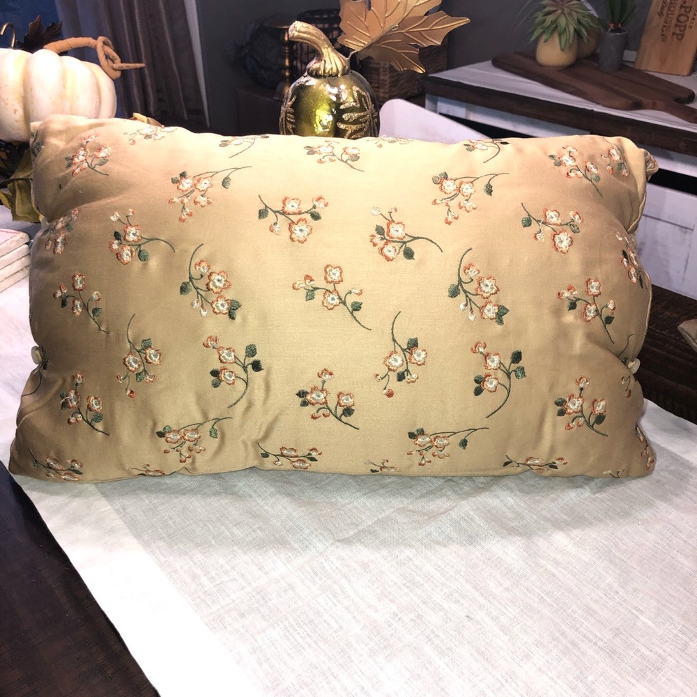 Decorative pillow w/embroidered delicate flowers. Has buttons on the side